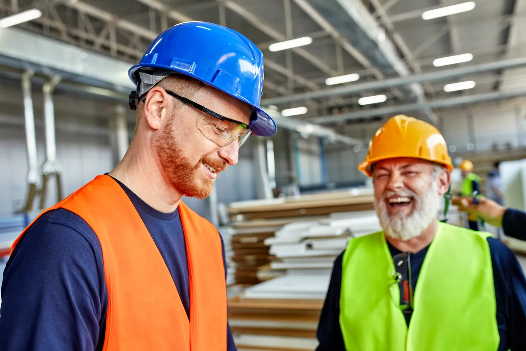 two workers in warehouse with hi viz jackets
